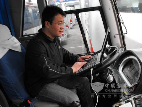张海明在检查客车发动机情况